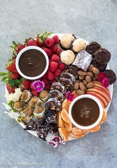 an assortment of desserts on a platter with chocolate sauce