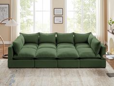 a large green couch sitting in front of two windows