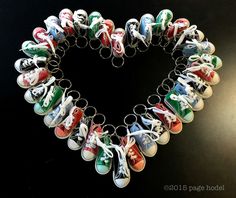 a heart shaped keychain with many pairs of shoes hanging from it's sides