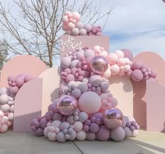 a pink and white cake with balloons on it