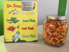 a jar filled with fish next to a book