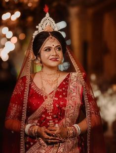 a woman in a red and gold bridal outfit