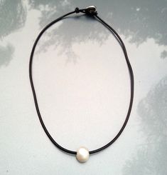 Black leather necklace, delicate, minimalist and fun necklace for women, black leather and a high quality 10-11 mm freshwater baroque pearl. The button clasp is silver plated with sterling silver, free of lead, nickel, cadmium. Hypoallergenic. Can be easily maintained by occasionally buffing them with a polishing cloth. Available in black, distressed brown, distressed light brown, blue and red brick leather. This Necklace is 18 inches long, can be adjusted to any size. Please let me know if you Elegant Sterling Silver Necklace With Adjustable Cord, Classic Jewelry With Adjustable Cord As A Gift, Elegant Adjustable Cord Choker As Gift, Elegant Adjustable Cord Choker, Classic Adjustable Cord Jewelry As Gift, Minimalist Handmade Pearl Necklace, Minimalist Adjustable Pearl Choker Necklace, Handmade Adjustable Minimalist Pearl Necklace, Adjustable Sterling Silver Minimalist Pearl Necklace