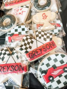 decorated cookies in the shape of cars and checkered flags are on display for sale