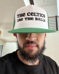 a man with a beard wearing a hat that says the celtics are the balls