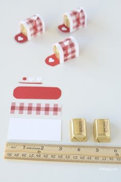 there are several pieces of paper and tape on the table next to each other, including two gold - plated cufflinks