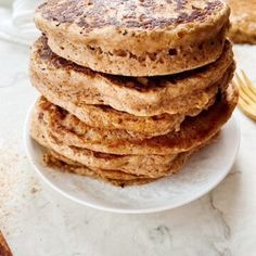 a stack of pancakes sitting on top of a white plate