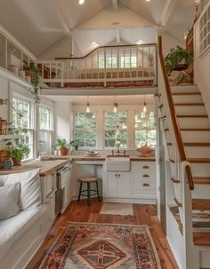 a kitchen and living room with stairs leading to the second floor