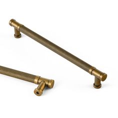 two brass colored handles on a white background