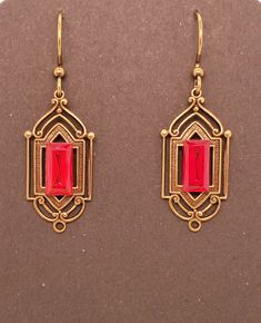 Ruby Red Crystal Art Deco Earrings have an antique brass base which is a metal stamping with hollow back. Centered large rectangular vintage crystal chaton with gold back. Earrings dangle from antique brass tone ear wires. These are Takeen Arts original and one-of-a-kind (OOAK). Designed and created by TLP and staff for Takeen Arts. Item E841. Formal Red Brass Earrings, Vintage Red Brass Earrings, Vintage Rectangular Metal Earrings, Art Deco Red Rectangular Jewelry, Red Rectangular Art Deco Jewelry, Red Art Deco, Deco Earrings, Red Art, Art Deco Earrings