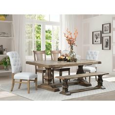 a dining room table with white chairs around it