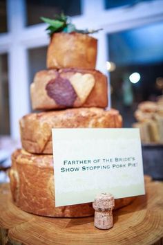 a cake made out of bread with a sign that says father of the bride's show stopping pork pie