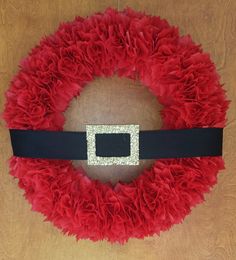 a red wreath with a black ribbon and glitter buckle