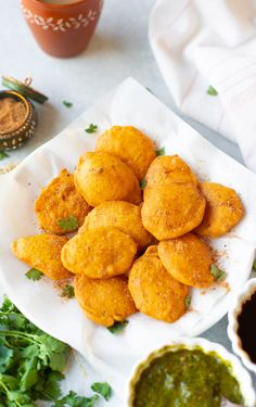 fried aloo pakora on a white plate with cilantro sauce