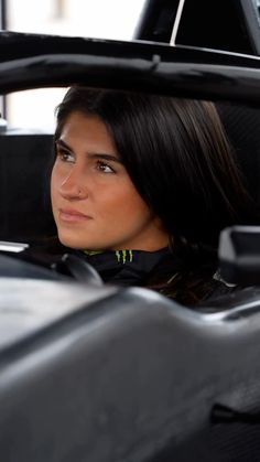 a woman sitting in the back seat of a car looking at something off to the side