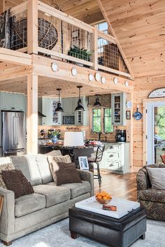 a living room filled with furniture next to a kitchen and an open concept floor plan