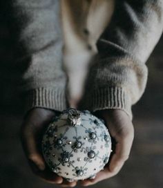 a person holding a white and black ornament in their hands