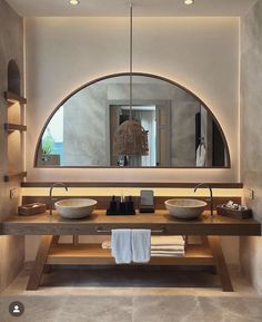 a bathroom with two sinks and a large round mirror above the sink in front of it