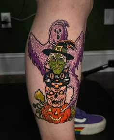 a woman's leg with halloween tattoos on it