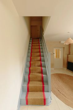 there is a set of stairs with red carpet on the bottom and bottom steps to the second floor