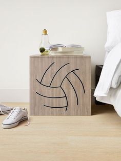 a wooden box with a volleyball ball on it next to a pair of tennis shoes