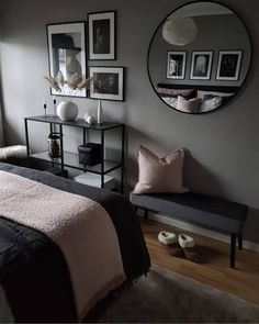 a bed room with a neatly made bed and some pictures on the wall above it