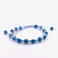 a beaded bracelet with blue glass beads and silver wire on a white background photo