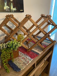 there is a wooden rack on top of a table next to a potted plant