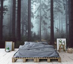 a bed sitting in front of a forest wall mural