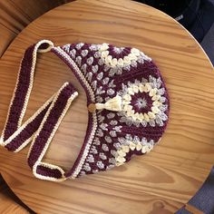 a crocheted purse sitting on top of a wooden table