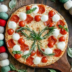 a pizza with tomatoes, mozzarella and basil on it next to other ingredients