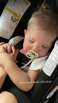 a baby sleeping in a car seat with a pacifier in it's mouth