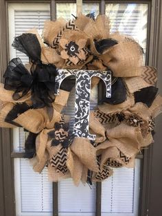 a wreath that has the letter t on it and is decorated with burluck