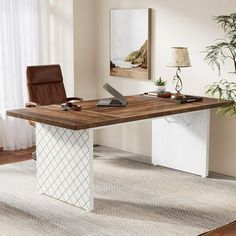 a desk with a laptop on it in front of a chair and potted plant