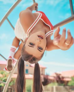 a girl upside down on a metal pole