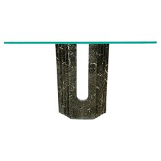 the letter u is made out of black marble and has a glass shelf underneath it