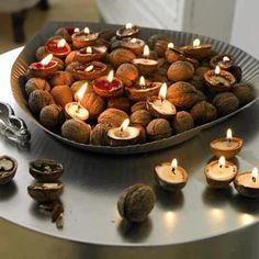 some nuts are on a table with candles in the middle and one is lit up