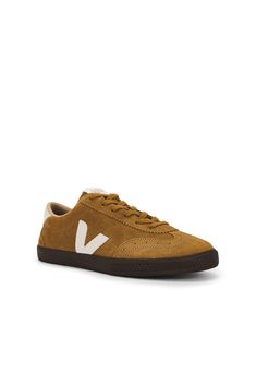 Suede upper and rubber sole.  Made in Brazil.  Lace-up front.  Leather V-logo at sides.  Leather debossed Veja logo at back counter.  Embroidered logo at tongue.  Perforated toe.  Round toe.  .  .  .  .  .  .  .  . Veja Volley, Made In Brazil, Tan Suede, Sneaker Brands, South America, Rubber Sole, Cotton Canvas, Tent, Organic Cotton