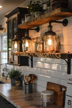 some mason jars are hanging on the wall above a kitchen counter with wood planks