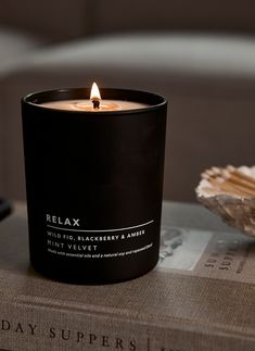 a candle sitting on top of a book next to a seashell and sea shell