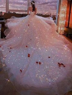 a woman in a wedding dress is standing near a window with stars on it and looking at the sky