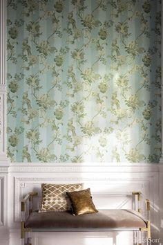 a bench in front of a wallpapered wall with flowers and leaves on it