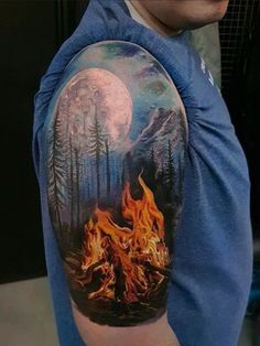 a man with a half sleeve tattoo on his arm that has a campfire and mountains in the background