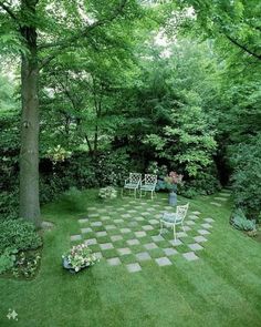 an outdoor area with chairs and tables in the middle of it, surrounded by trees