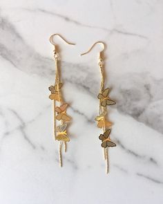 Gorgeous gold butterfly dangle earrings! Each pair comes with silicone earring backs. Dangle Butterfly Earrings, Hoco Jewelry Gold Earrings, Gold Butterfly Charm Earrings, Gold Plated Dangle Earrings, Dangly Earrings Aesthetic, Butterfly Gold Earrings, Dangly Gold Earrings, Gold Butterfly Jewelry, Gold Butterfly Earrings