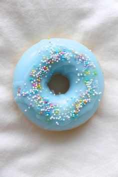 a blue donut with sprinkles on it sitting on a white napkin