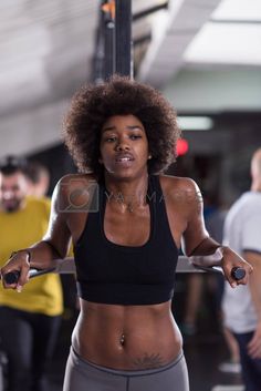 a woman with an afro holding a barbell