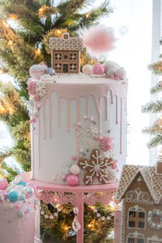 a three tiered cake decorated with pink icing and snowflakes on top