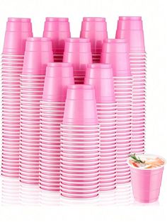 a stack of pink cups sitting next to each other on top of a white table