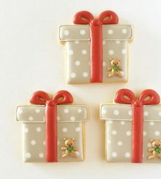 three decorated cookies with bows and presents on them